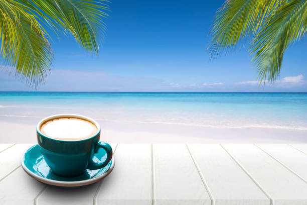 istock Coffee in cup on wooden table with sea view background in summer. 825875178
