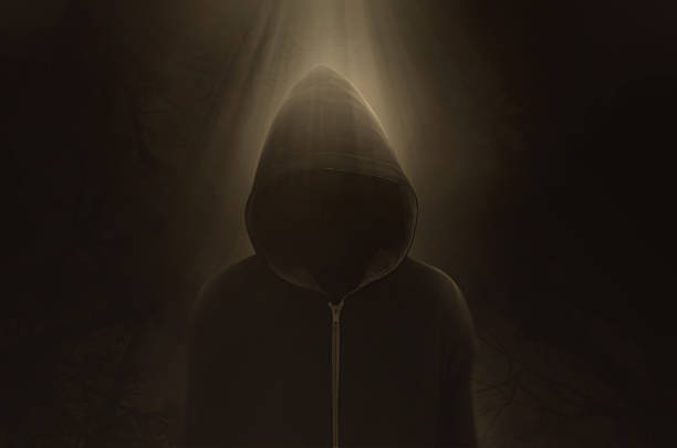 Halloween Concept, A dark and sinister figure in a hood against black.