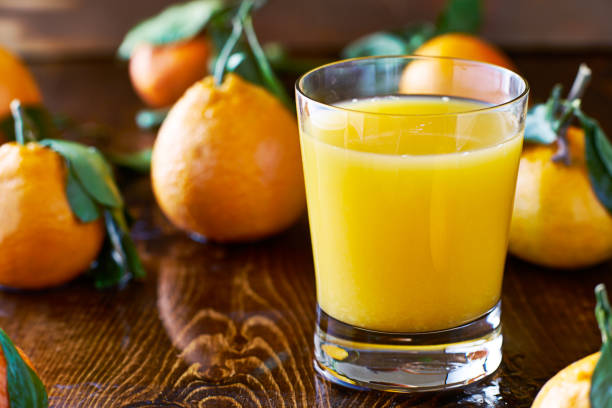 istock fresh glass of orange juice on rustic table top 825882942
