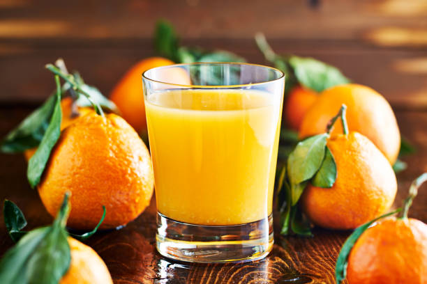 istock fresh glass of orange juice on rustic table top 825882960