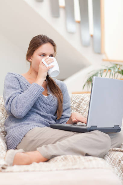 istock Portrait of a woman using a laptop while drinking a cup of tea 825883030