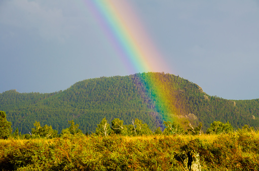 A rainbow against the background of the mountains. Borovoe Kazakhstan Burabay.