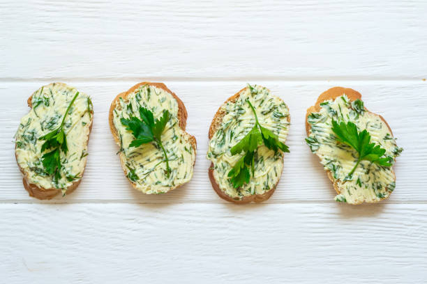 istock Sandwiches with herbs butter on white wooden background 825892222