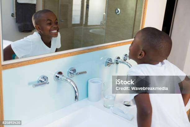 High Angle View Of Boy Clenching Teeth While Looking At Mirror Stock Photo - Download Image Now