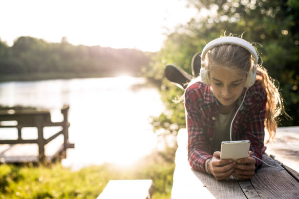 Young girl using smartphone at the lake
