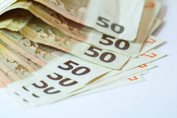 istock Fifty euro banknotes on white wooden background 825896236