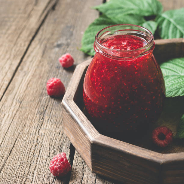 istock Jar with homemade raspberry jam on a tray, copy space 825898958