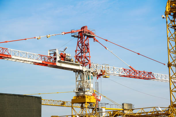 istock Part of yellow construction tower crane arm against blue sky 825899836