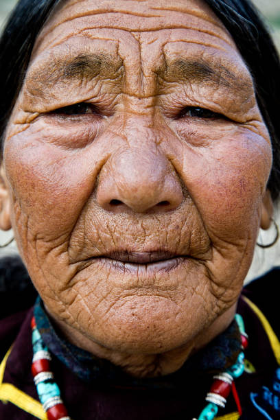 Close-up portrait of elderly Buddhist woman in traditional clothing