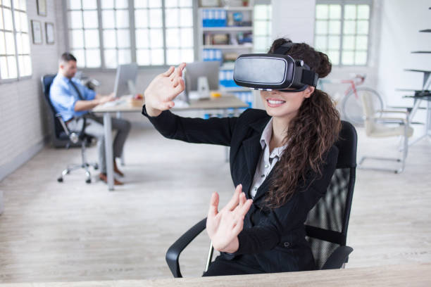 istock Young woman with VR headset in modern office 825903378