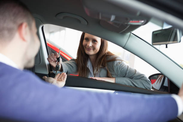 istock Woman giving car keys to a customer 825903414