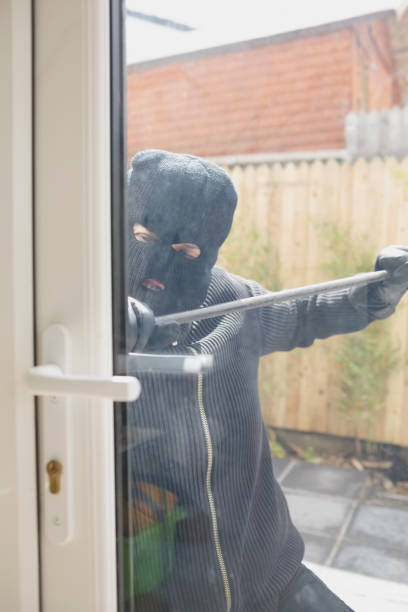 istock Burglar opening door with crow bar 825911746