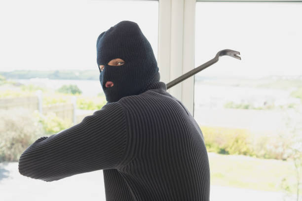 istock Burglar swinging crow bar 825911820