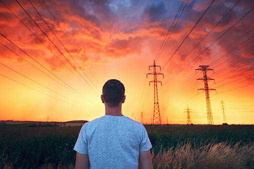 Dangerous weather. Lonely man in stunning storm during colorful sunset.