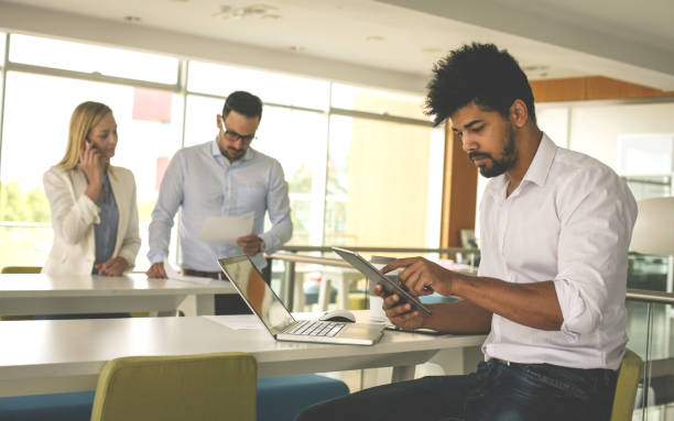 istock African American business man using technology  at the office. People working in office. 825918144