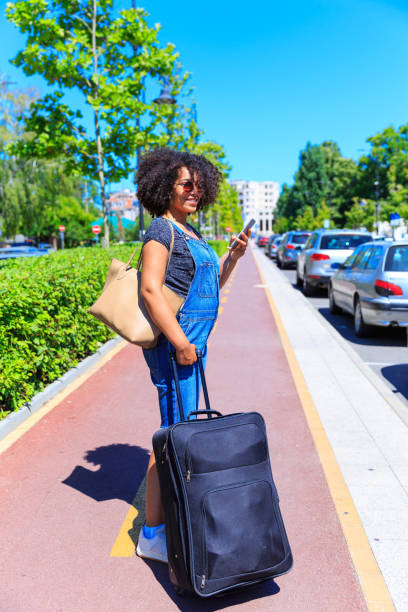 istock Tourist with suitcase using smart phone on street 825919002