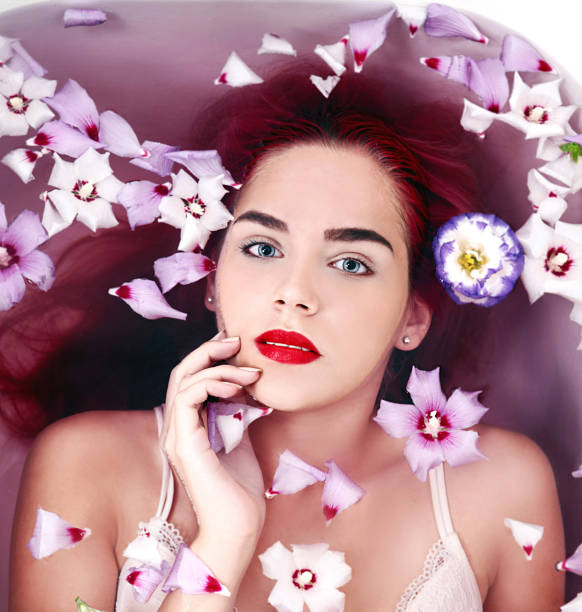 istock Young woman in bath with flowers 825922044