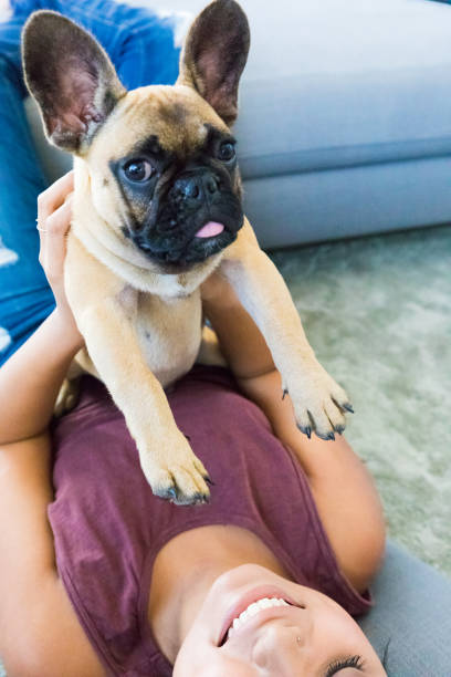 Young Latin woman playing with her puppy