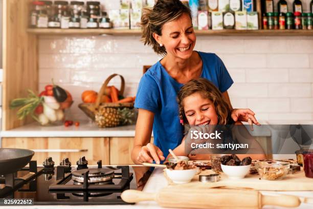 Bambina Che Cucina Con Sua Madre In Cucina - Fotografie stock e altre immagini di Cucinare - Cucinare, Famiglia, Cucina