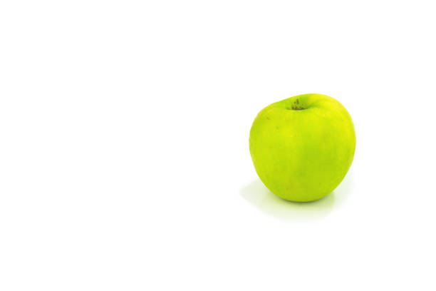 Green apple isolated on white background. Selected focus, shallow DOF. Blur group of sweet fruits on background.