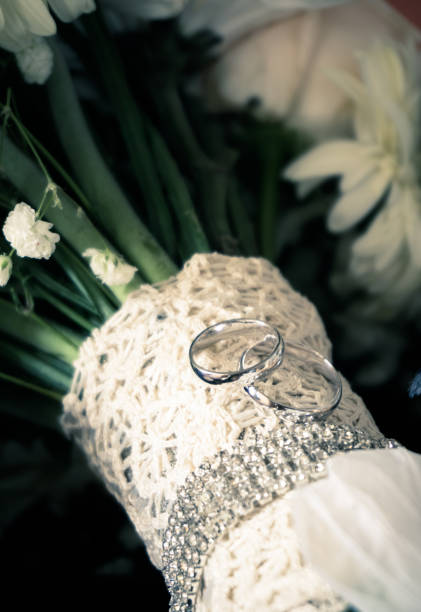 istock Wedding Rings on Lace Bouquet wrapped in Diamonds 825927894