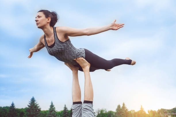 istock People practice acro yoga outdoors healthy lifestyle 825931118