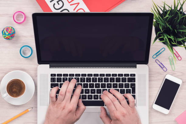 istock Top view flat lay workspace mockup with smartphone and open laptop with mans hands on office desk 825931546