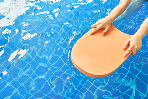 Foam board and hands in the middle of the pool, which is a niche for swimming practice. Made of foamed foam seed plastic.