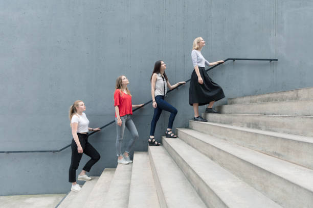 istock Young women standing on stairs by concrete wall 825941610