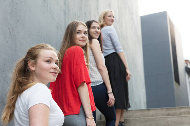 istock Young women standing on stairs by concrete wall 825944270