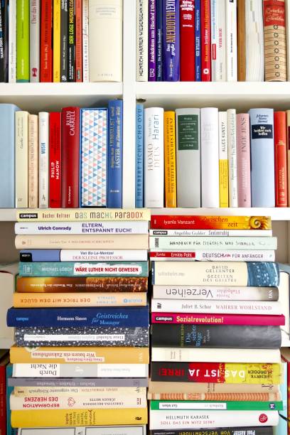 istock Filled books shelf close up with a stack of books leaning at it 825948342