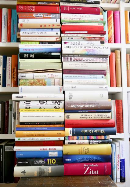 istock Filled books shelf close up with a stack of books leaning at it 825948552