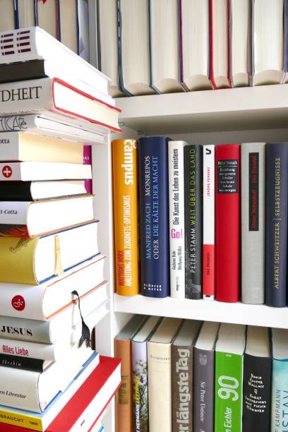 istock Filled books shelf close up with a stack of books leaning at it 825948618