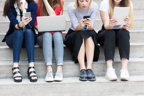 istock Young women working with technologies while they are sitting on the stairs 825949450