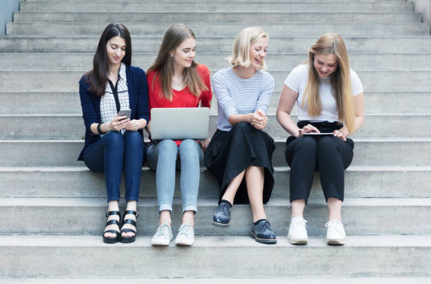 istock Young women working with technologies while they are sitting on the stairs 825952514