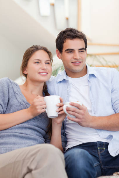 istock Portrait of a couple drinking coffee while watching TV 825952564