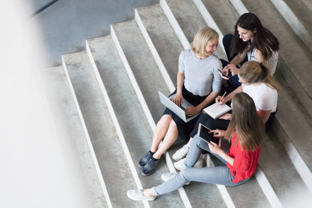istock Young women working with technologies while they are sitting on the stairs 825953928