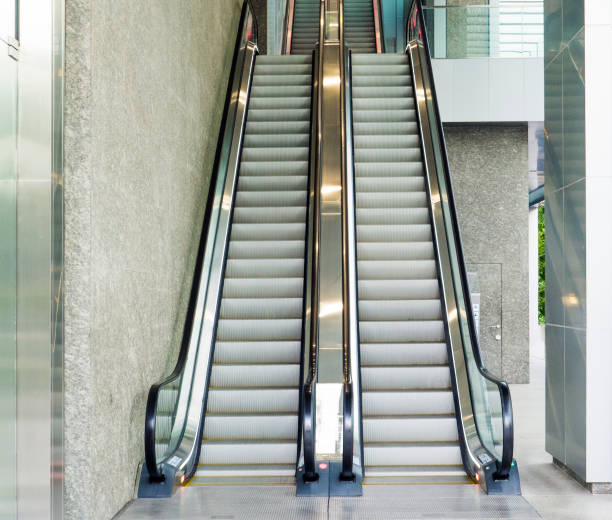 istock escalator,Up and down escalators in public building 825956622