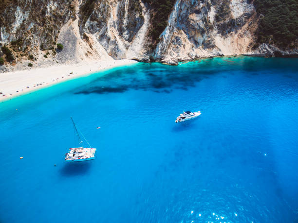 istock Catamaran at anchor in front of a popular beach 825958182