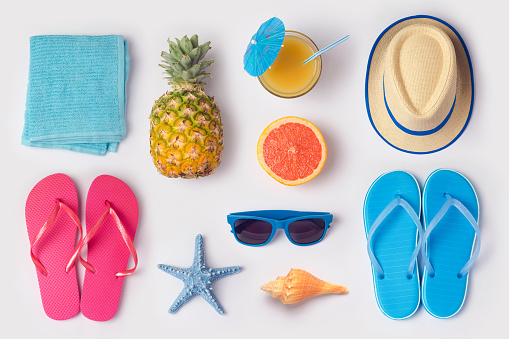 Concepto de vacaciones de verano tropical con piña, el jugo y ojotas organizado sobre fondo blanco. Vista desde arriba. Endecha plana photo