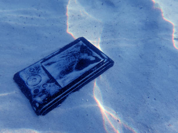 istock Compact camera on the sand under sea water 825978508