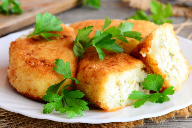 istock Vegetable cakes with egg stuffing on a white plate. Cakes cooked from cauliflower and potatoes and stuffed with boiled sliced eggs. Rustic style. Closeup 825985352