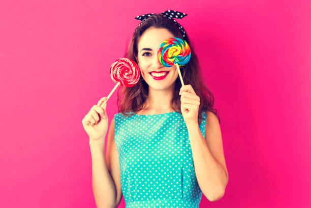 istock Young woman holding lollipops 825989310