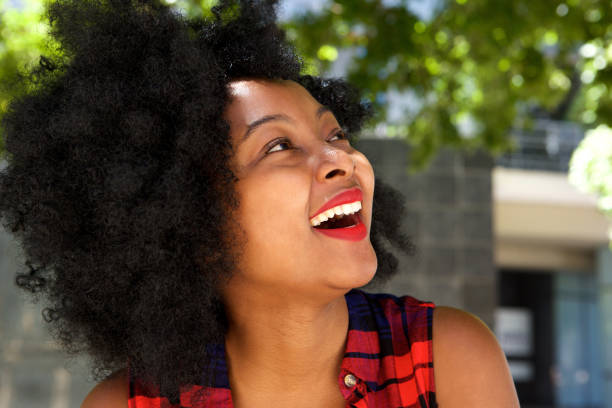 istock beautiful young african woman laughing outside 825993010