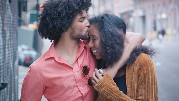 attraente coppia afroamericana camminare e baciare su urban street - couple black american culture kissing foto e immagini stock