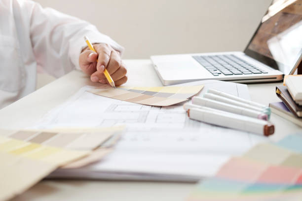 istock Graphic design and color swatches and pens on a desk. Architectural drawing with work tools and accessories. 825993822