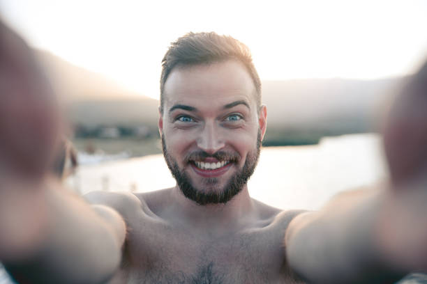 istock Young Smiling Boy with Blue Eyes Taking Selfie on Beach in Summer 825997570