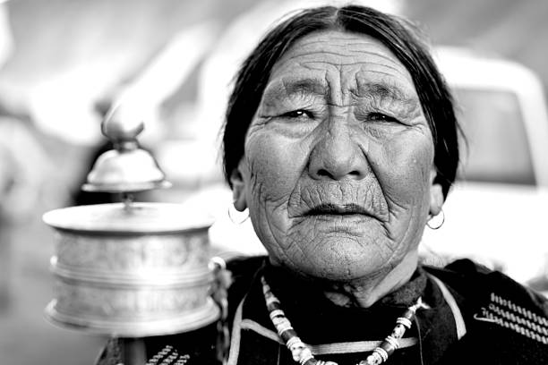 Elderly woman holding hand prayer wheel