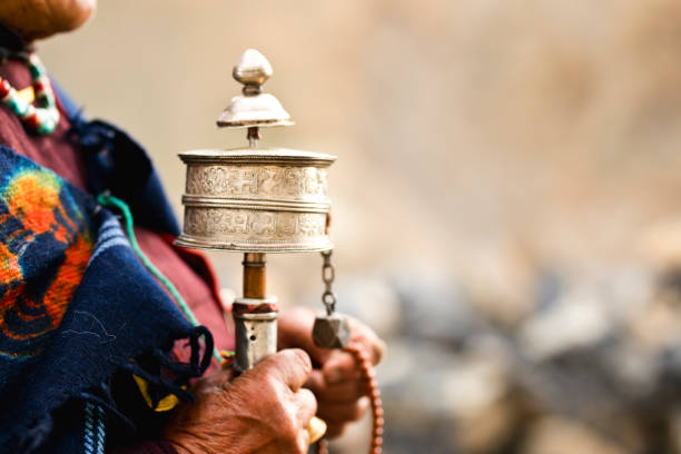 Midsection of woman holding hand prayer wheel and prayer beads