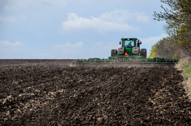Tractor cultivating field stock photo